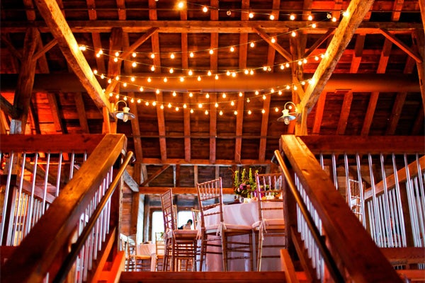 Inside of Pat's Barn showing string light decorations and decorated tables. 