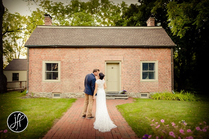 Bride and groom on a walkway facing away from the camera outside of Pat's Barn.